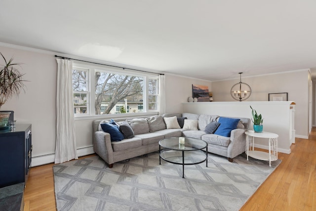 living area with light wood-style floors, baseboard heating, a chandelier, and crown molding