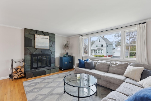 living area with plenty of natural light, wood finished floors, and ornamental molding