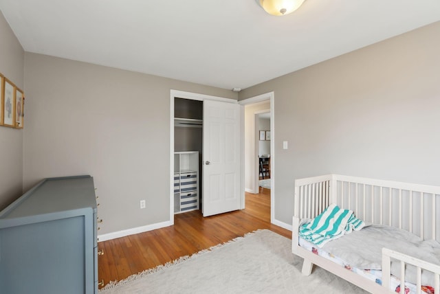 bedroom with baseboards, a closet, and wood finished floors