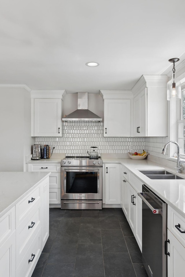 kitchen with white cabinets, wall chimney exhaust hood, stainless steel appliances, and a sink