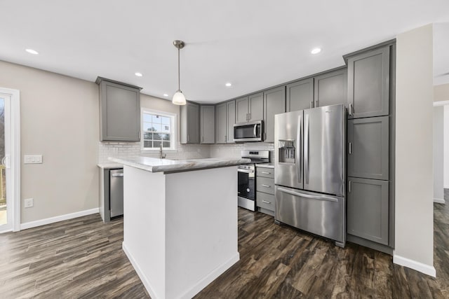 255 Cushing Rd, Cushing, ME 04863 - kitchen featuring appliances with stainless steel finishes, gray cabinetry, dark wood-type flooring, tasteful backsplash, and baseboards