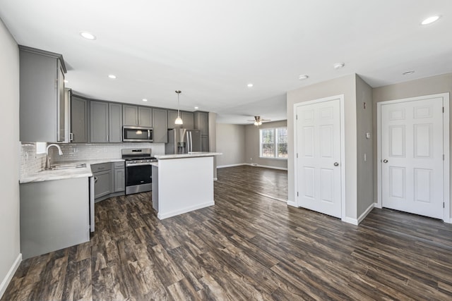 255 Cushing Rd, Cushing, ME 04863 - kitchen with appliances with stainless steel finishes, gray cabinetry, a sink, baseboards, and dark wood-style flooring