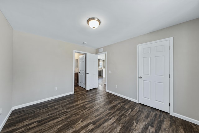 255 Cushing Rd, Cushing, ME 04863 - unfurnished bedroom featuring baseboards, dark wood-type flooring, and ensuite bath