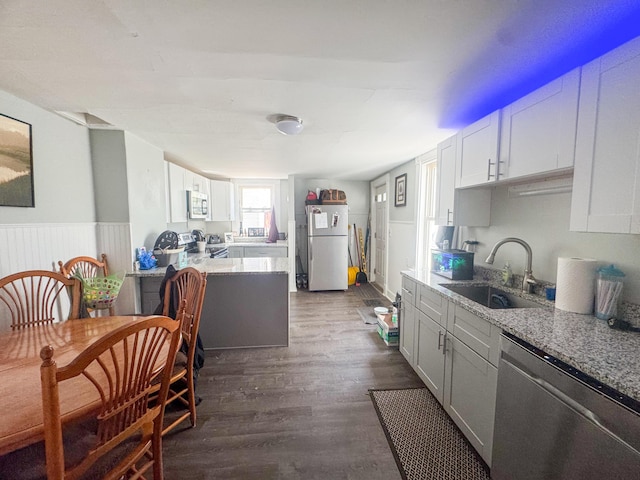 6 Hudson St, Bangor, ME 04401 - kitchen with a sink, stainless steel appliances, dark wood-type flooring, wainscoting, and light stone counters