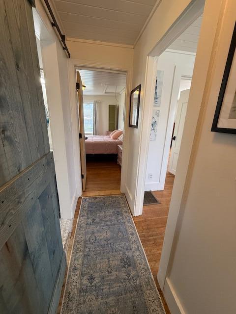 7 Johnson St, Eastport, ME 04631 - hallway featuring crown molding, wood finished floors, and a barn door