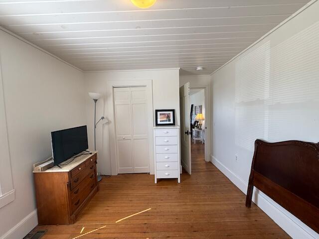 7 Johnson St, Eastport, ME 04631 - bedroom with a closet, light wood-style floors, baseboards, and crown molding