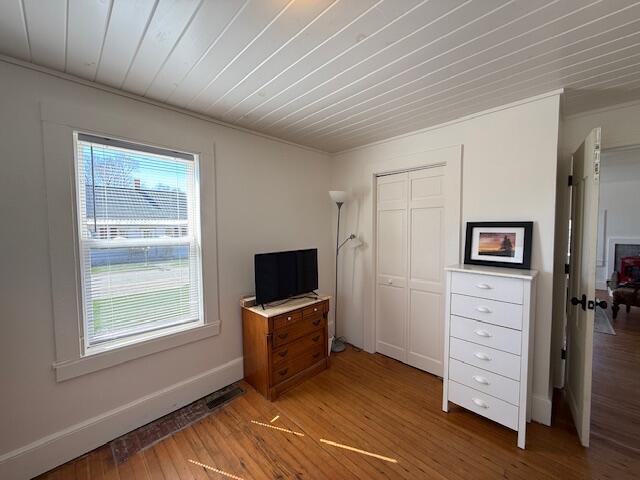 7 Johnson St, Eastport, ME 04631 - unfurnished bedroom with baseboards, crown molding, a closet, and light wood-type flooring