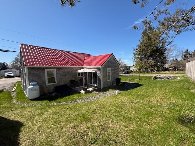 7 Johnson St, Eastport, ME 04631 - back of property with a lawn and metal roof