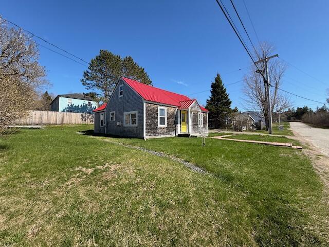 7 Johnson St, Eastport, ME 04631 - back of house featuring a lawn, metal roof, and fence