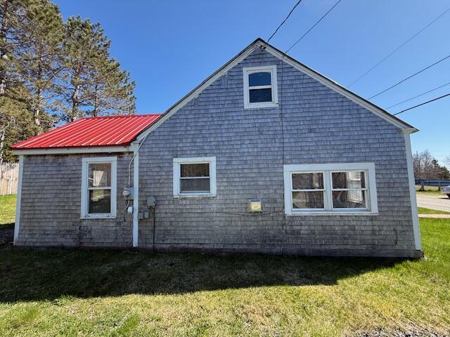 7 Johnson St, Eastport, ME 04631 - view of side of home with metal roof and a lawn