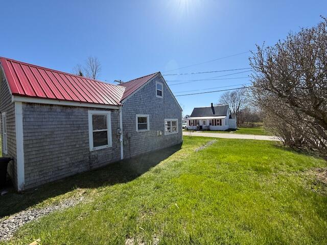7 Johnson St, Eastport, ME 04631 - view of side of property with a lawn and metal roof