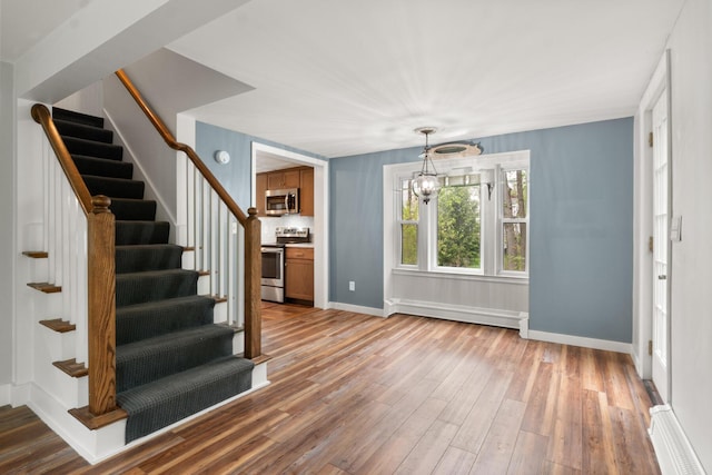 8 Organug Rd, York, ME 03909 - entrance foyer featuring stairs, a baseboard heating unit, wood finished floors, baseboards, and a chandelier
