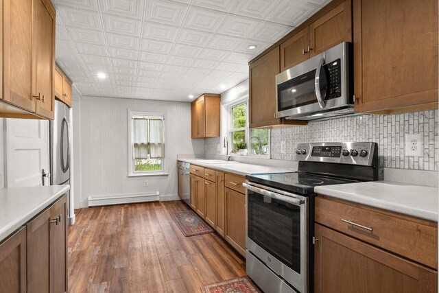 8 Organug Rd, York, ME 03909 - kitchen featuring appliances with stainless steel finishes, a baseboard radiator, a sink, backsplash, and dark wood finished floors