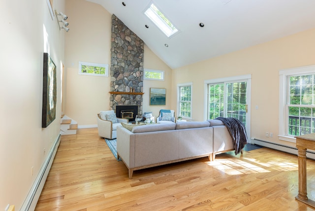 148 Hunter Way, Falmouth, ME 04105 - living area with high vaulted ceiling, light wood-style floors, a stone fireplace, a skylight, and a baseboard heating unit