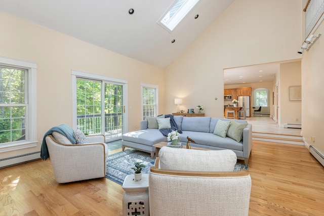 148 Hunter Way, Falmouth, ME 04105 - living room with a baseboard heating unit, high vaulted ceiling, a skylight, and light wood-type flooring