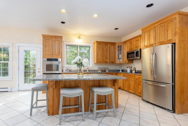 148 Hunter Way, Falmouth, ME 04105 - kitchen featuring appliances with stainless steel finishes, light tile patterned flooring, stone countertops, a kitchen island, and recessed lighting