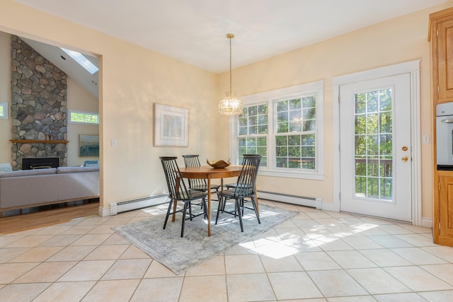 148 Hunter Way, Falmouth, ME 04105 - dining space featuring a baseboard heating unit, a fireplace, light tile patterned flooring, a chandelier, and lofted ceiling