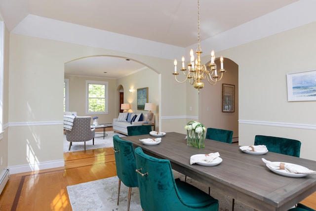 148 Hunter Way, Falmouth, ME 04105 - dining area with arched walkways, light wood-type flooring, a chandelier, and baseboards