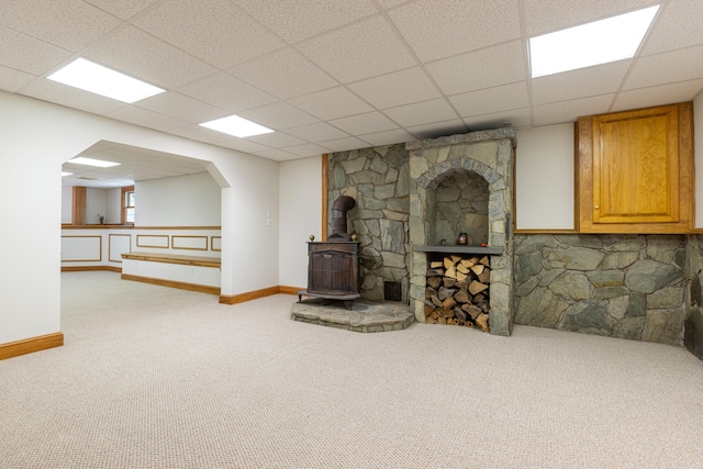 148 Hunter Way, Falmouth, ME 04105 - unfurnished living room featuring a wood stove, carpet flooring, baseboards, and a paneled ceiling