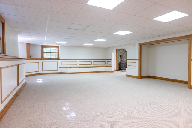 148 Hunter Way, Falmouth, ME 04105 - basement featuring a wood stove, light carpet, a drop ceiling, and baseboards