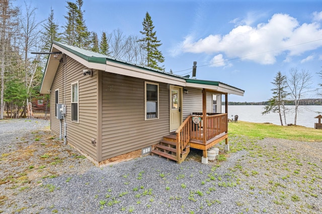 back of house featuring a water view and metal roof