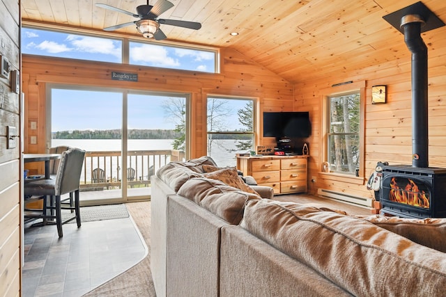 living area with a wood stove, baseboard heating, wooden ceiling, vaulted ceiling, and a ceiling fan
