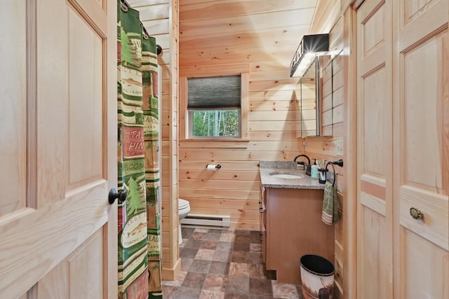 bathroom with wooden walls, a baseboard radiator, toilet, vanity, and stone finish flooring