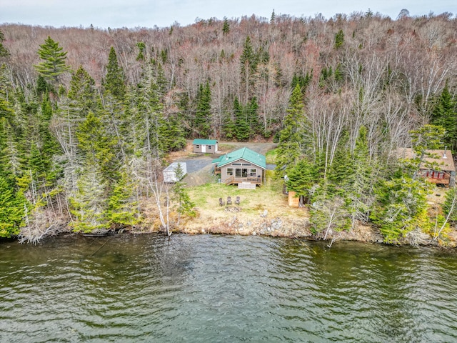 aerial view of property and surrounding area with a forest and a large body of water