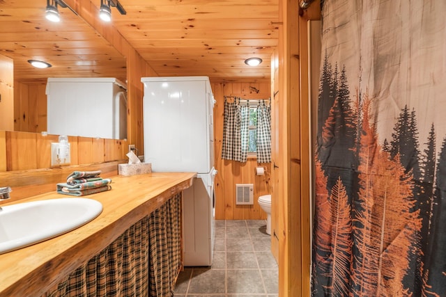 129 Diller Line Rd, Chesterville, ME 04938 - bathroom with wood walls, vanity, toilet, wooden ceiling, and tile patterned floors