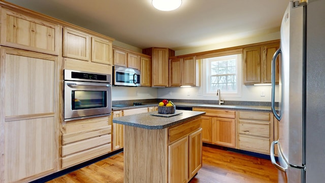 48 Lubear Way, Auburn, ME 04210 - kitchen with stainless steel appliances, a sink, light brown cabinets, dark countertops, and light wood-type flooring