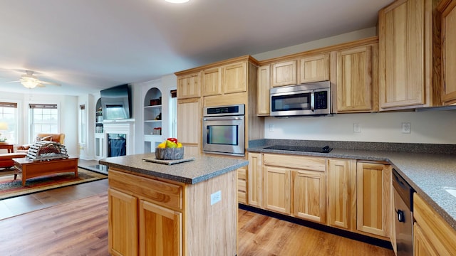48 Lubear Way, Auburn, ME 04210 - kitchen with stainless steel appliances, light brown cabinets, light wood finished floors, a fireplace, and a ceiling fan