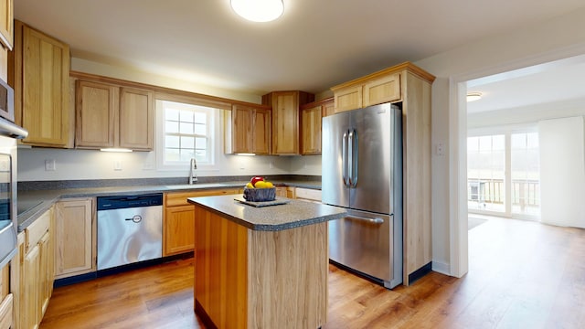 48 Lubear Way, Auburn, ME 04210 - kitchen featuring stainless steel appliances, light wood finished floors, a sink, dark countertops, and a center island
