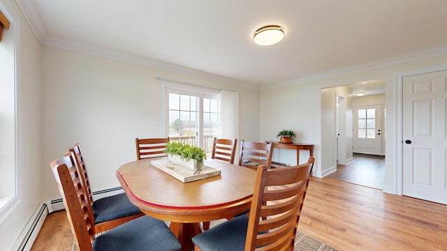 48 Lubear Way, Auburn, ME 04210 - dining room featuring baseboard heating, light wood-style floors, ornamental molding, and baseboards