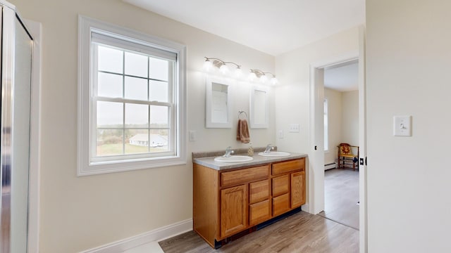 48 Lubear Way, Auburn, ME 04210 - full bath with double vanity, a baseboard heating unit, wood finished floors, and baseboards