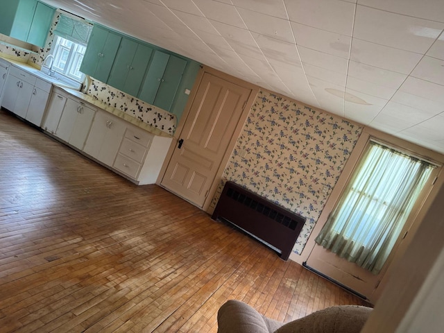 6 Mcdevitt Ln, Eastbrook, ME 04634 - unfurnished living room featuring radiator, light wood-type flooring, and wallpapered walls