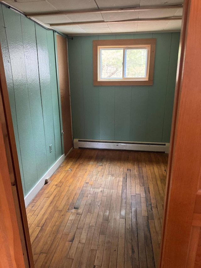 6 Mcdevitt Ln, Eastbrook, ME 04634 - spare room featuring wood-type flooring, baseboard heating, baseboards, and a drop ceiling