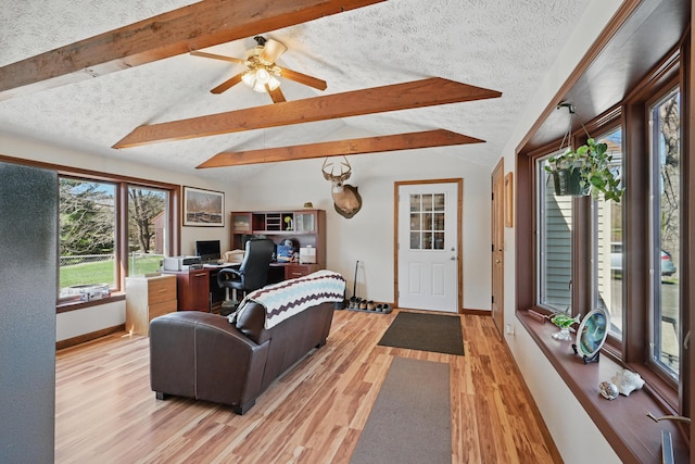 128 Capen Rd, Gardiner, ME 04345 - living room with light wood-style flooring, a ceiling fan, lofted ceiling with beams, a textured ceiling, and baseboards