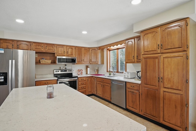 128 Capen Rd, Gardiner, ME 04345 - kitchen with recessed lighting, brown cabinetry, a sink, light countertops, and appliances with stainless steel finishes