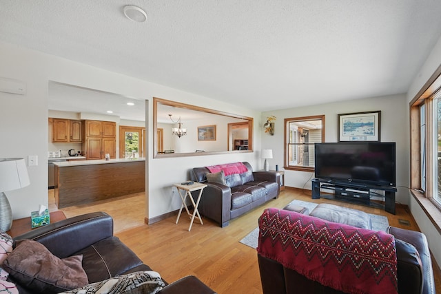 128 Capen Rd, Gardiner, ME 04345 - living room with light wood finished floors, recessed lighting, and an inviting chandelier