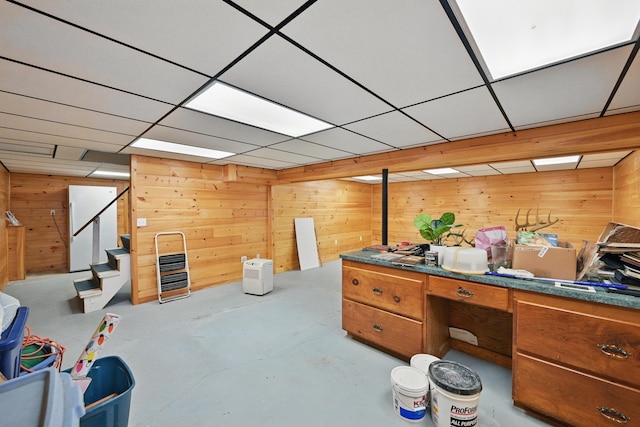 128 Capen Rd, Gardiner, ME 04345 - miscellaneous room with a drop ceiling, wooden walls, unfinished concrete flooring, and stairway