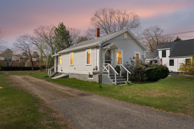 3333B Weymouth St, Brunswick, ME 04011 - view of front of home featuring a chimney, a front yard, and asphalt driveway