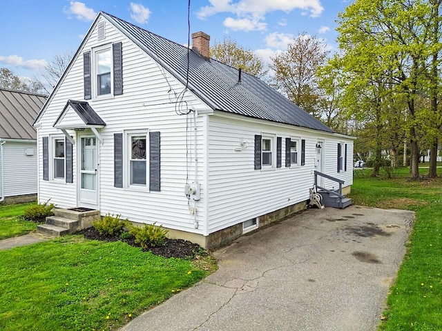 19 Fourth Ave, Augusta, ME 04330 - view of side of home with a chimney, metal roof, a lawn, and entry steps