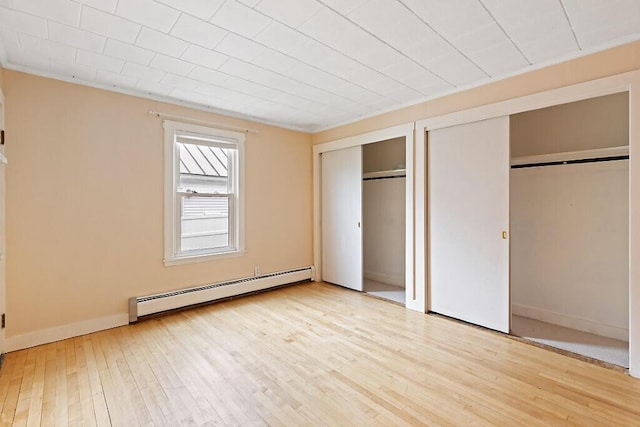 19 Fourth Ave, Augusta, ME 04330 - unfurnished bedroom with a baseboard heating unit, two closets, light wood finished floors, and baseboards