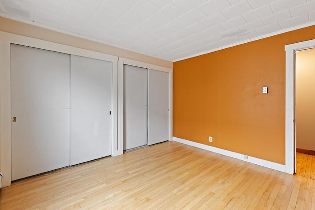 19 Fourth Ave, Augusta, ME 04330 - unfurnished bedroom with multiple closets, light wood-style floors, baseboards, and ornamental molding