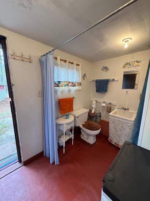 full bathroom featuring toilet, a sink, and baseboards