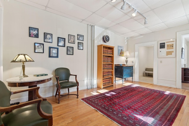 139 Newbury St, Portland, ME 04101 - sitting room featuring track lighting, a drop ceiling, baseboards, and hardwood / wood-style flooring