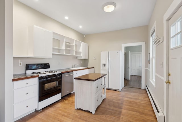 139 Newbury St, Portland, ME 04101 - kitchen with stainless steel dishwasher, a baseboard heating unit, white refrigerator with ice dispenser, a sink, and range with gas cooktop
