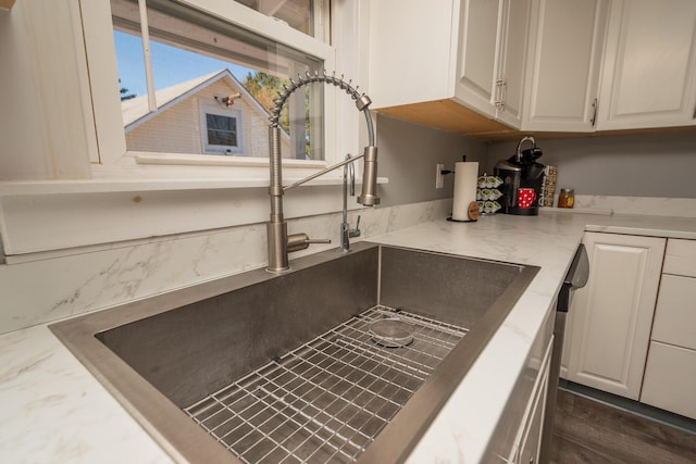 interior details with a sink and white cabinetry
