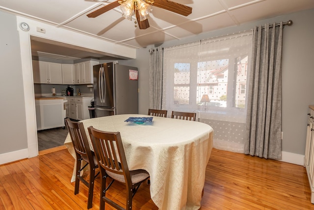 dining area with a ceiling fan and light wood-style floors