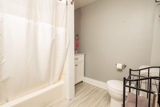 bathroom featuring toilet, wood finished floors, vanity, baseboards, and shower / bathtub combination with curtain